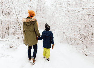 woman and child walking in snowy woods. Winter activities