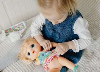 toddler girl playing with baby doll. Girl Mom. Des Moines Mom