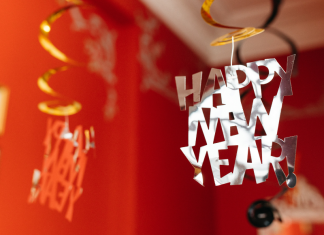 Red walls in a living room with a Happy New Year sign hanging from the ceiling