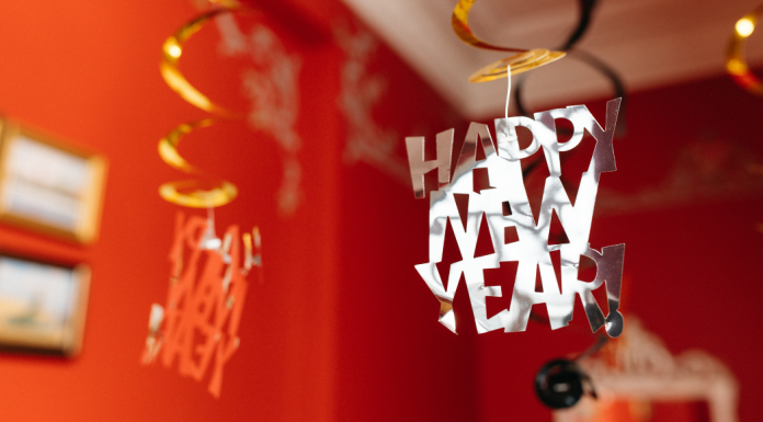 Red walls in a living room with a Happy New Year sign hanging from the ceiling