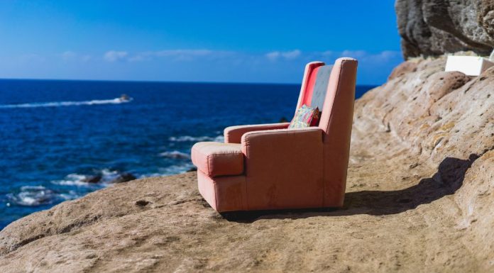 A comfy pink recliner on a picturesque beach. nursing chair